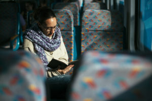 reading-woman-reading-book-on-train-bus